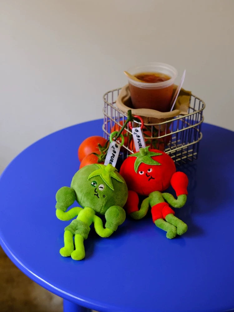 Wulibuddy Purr green Boxing Tomato Buddy plush bag  Charm & keychain accessory two plush keychains shaped like a green tomato  and a red tomato on a black leather bag.