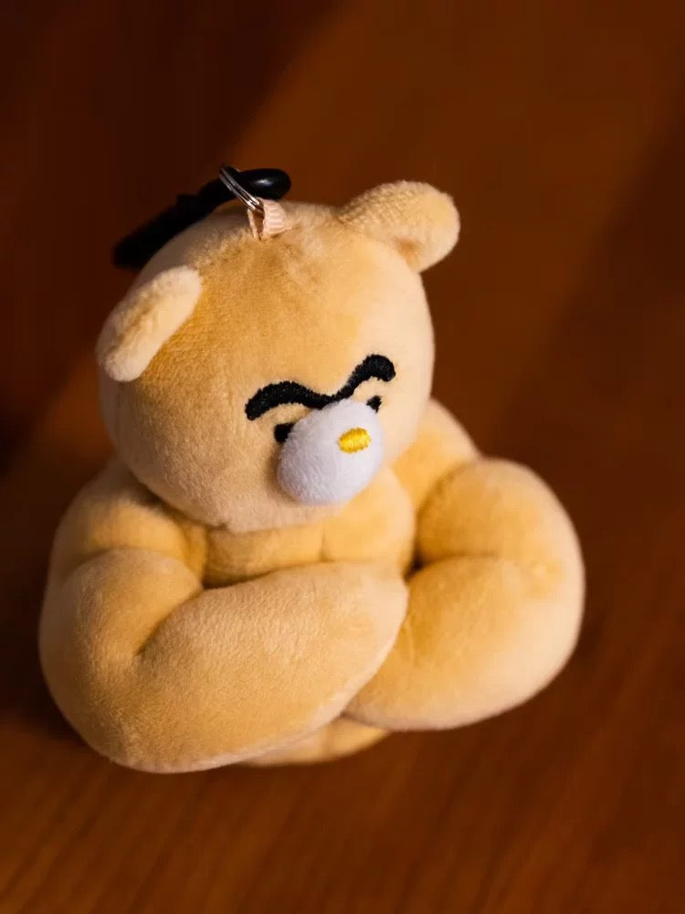 wulibuddy coach bear plush bag charm & keychain accessory crossed his arms and sitting on wooden surface