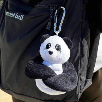wulibuddy Plush coach  panda keychain & bag charm attached to a black backpack.